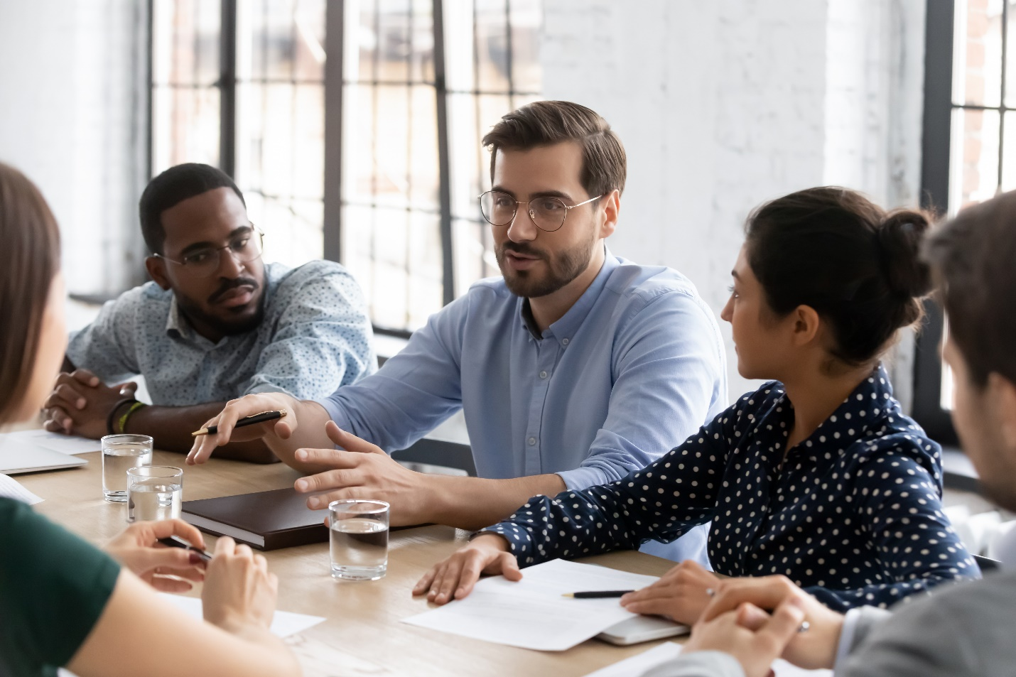 A photograph of diverse group of people in a meeting.