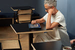 Photograph showing person sitting at a desk and reading.