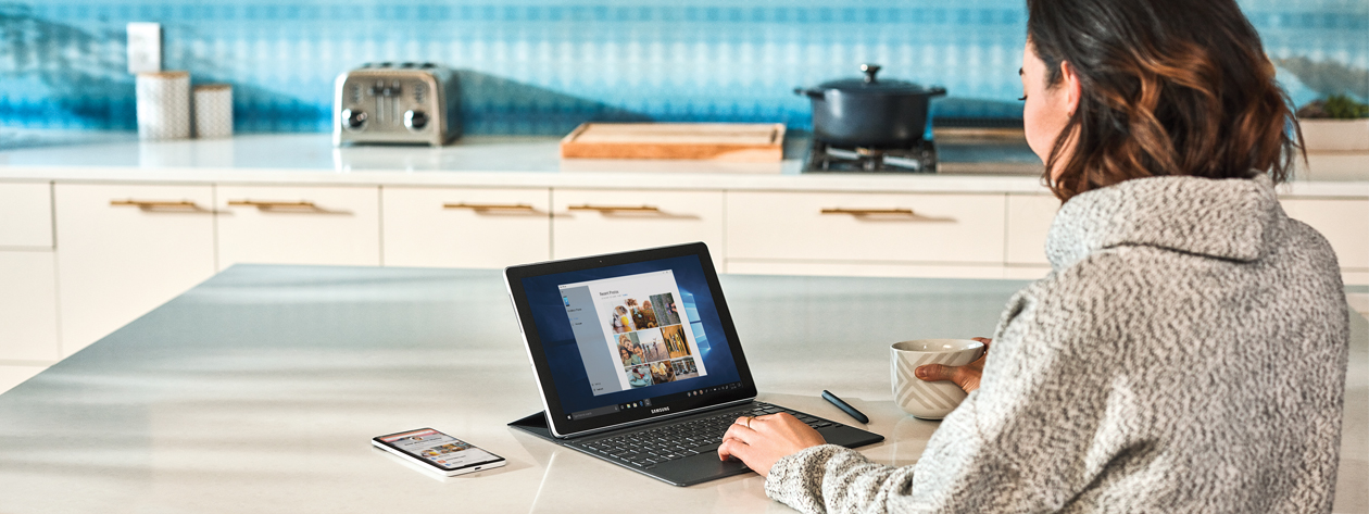 Une femme utilisant un appareil Microsoft Surface dans une cuisine