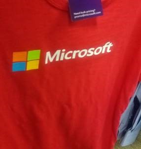 Üzerinde Microsoft etiketi ve logosu bulunan kırmızı bir gömlek